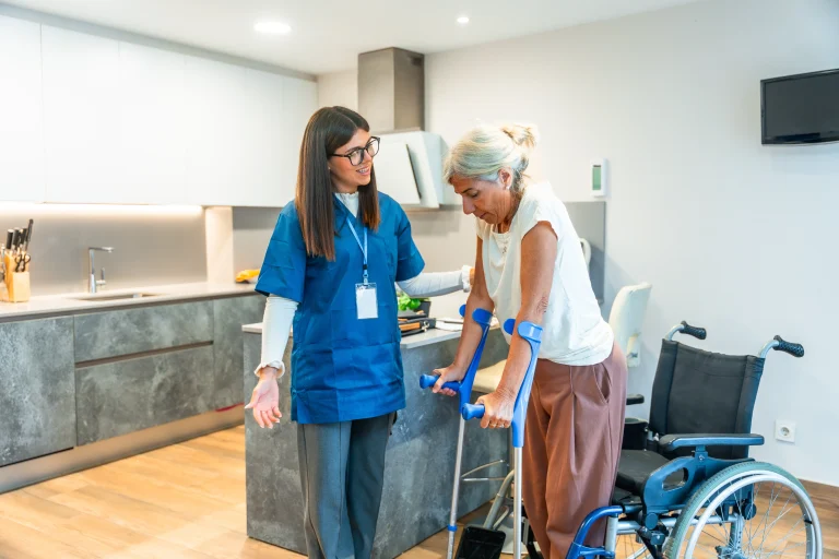 A nurse helping a senior woman using crutches.