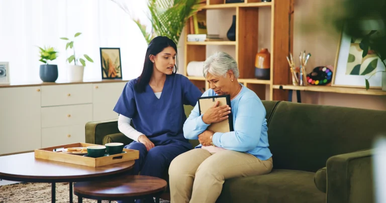 A caregiver comforting the old woman hugging a picture frame with dementia.