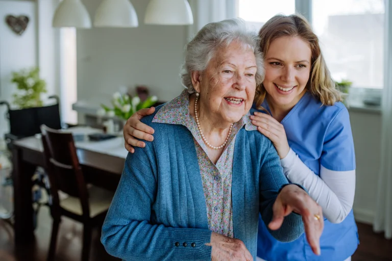 A young caregiver guiding her senior woman patient.